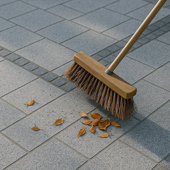 Symbolbild zur Granitplattenpflege - Besen und Laub