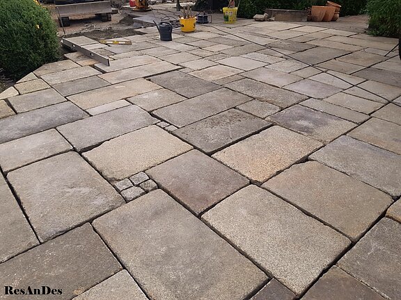 Graue Granitplatten im Römischen Verband verlegt